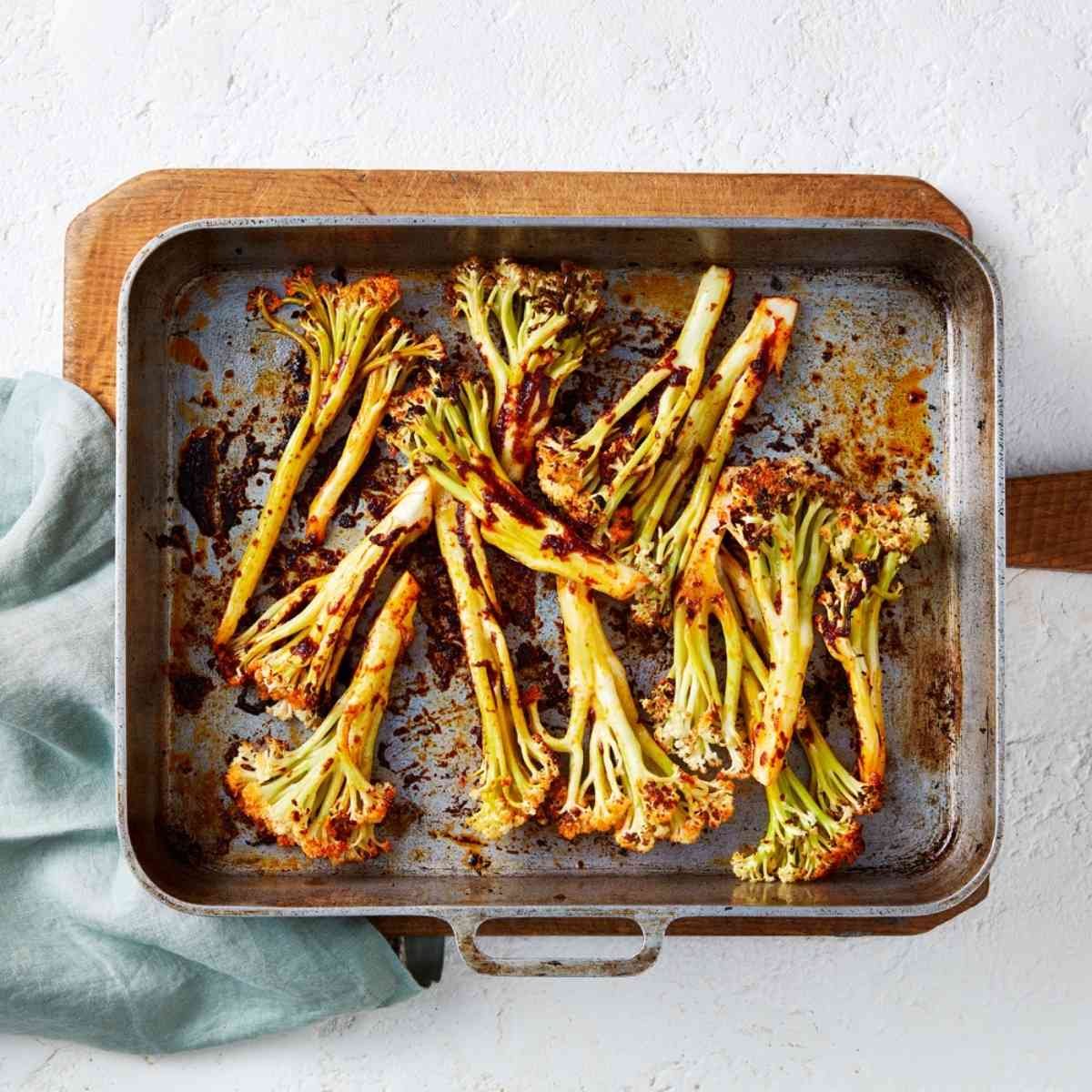 Roasted cauli-blossom florets in a large roasting tray.