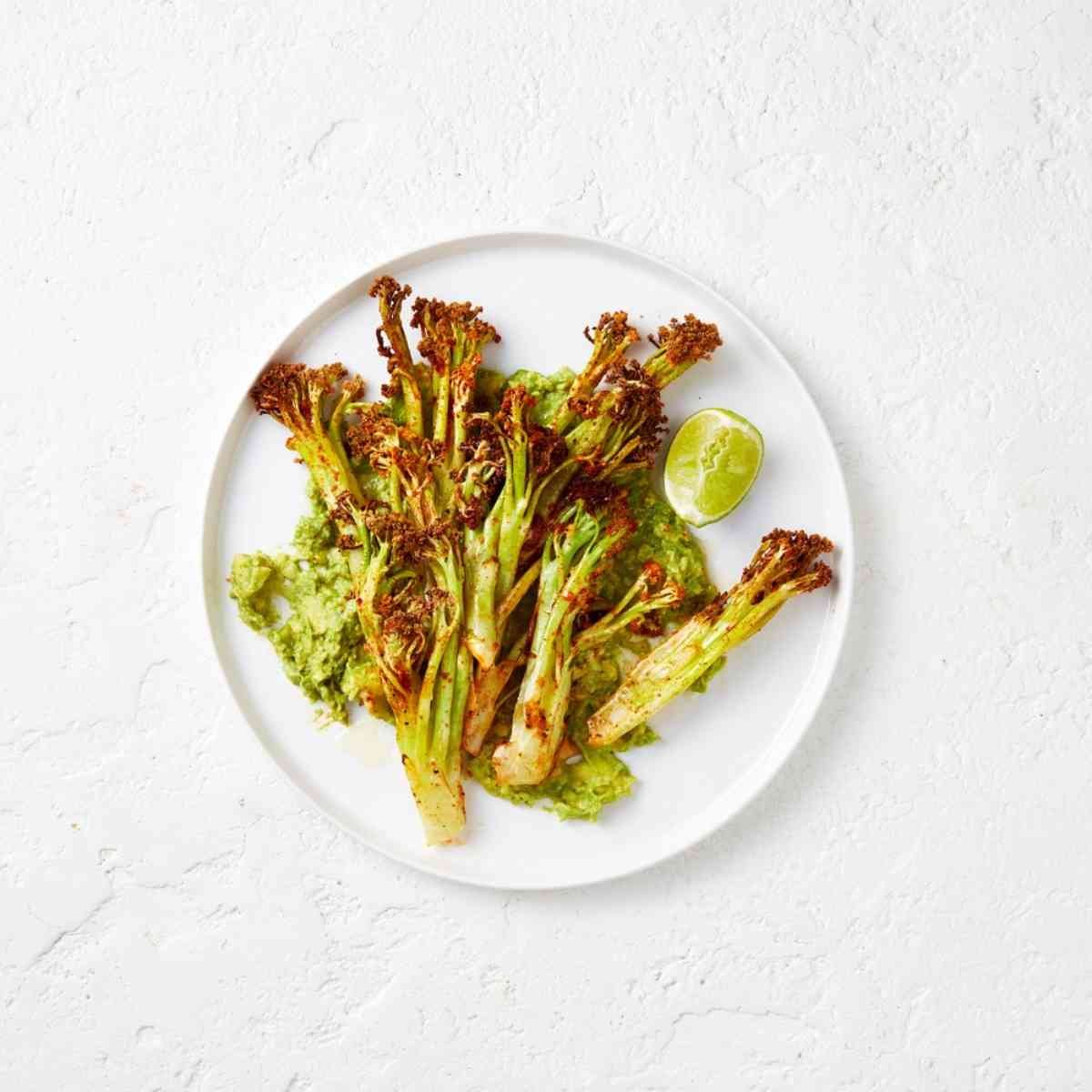 Cauliblossom florets tossed in a mexican seasoning, placed on a white plate.